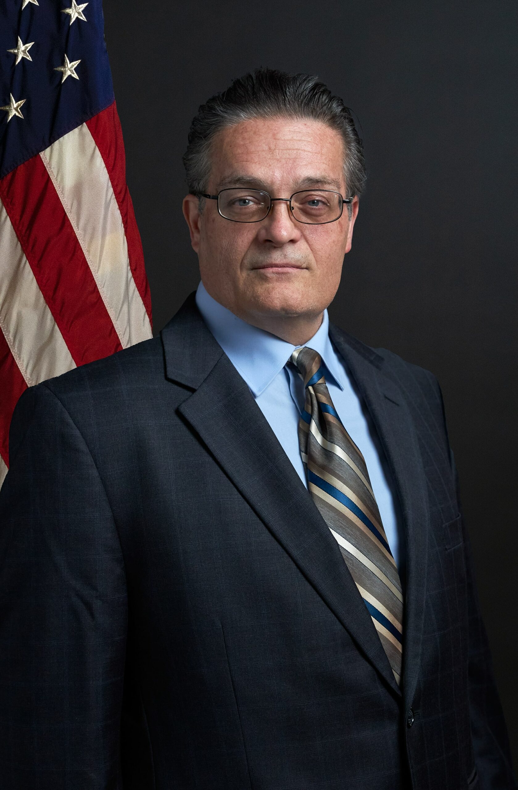 Photo of Curtis Clark with American flag behind him